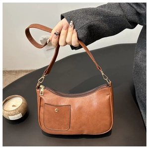 Detail shot of brown PU leather shoulder bag featuring a square pocket and gold buckle