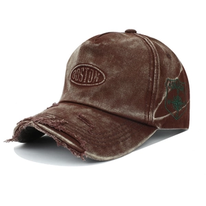 Detailed view of brown washed denim baseball cap with Boston embroidery and distressed holes