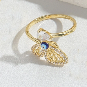 Macro detail of adjustable gold evil eye ring with blue zircon and teardrop crystal