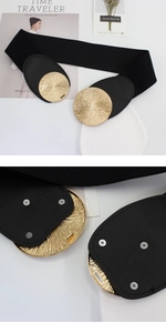 Detail of black wide elastic waist belt with gold circular brushed metal buckle and studs