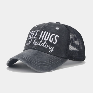Close-up of distressed brim and mesh detail on baseball cap with Free Hugs embroidery