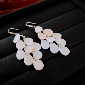 Detail of vintage water drop shell fringe earrings with cascading white pearly pendants