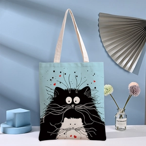 Light blue canvas tote bag with black and white cat illustration and thick straps