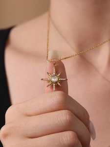 Détail d'un collier doré double épaisseur avec pendentif étoile scintillante serti