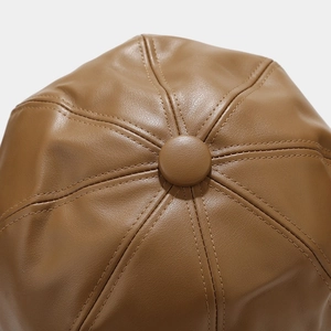 Detail view of the brown PU leather crown with eight-panel stitching and central button