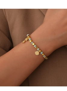 Detail of beaded bracelet with light green translucent beads and gold coconut palm pendants