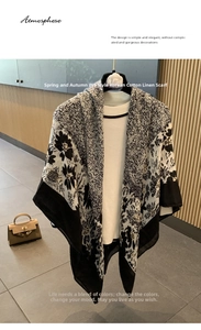 Detailed view of a black and white floral print cotton linen scarf draped on white clothing