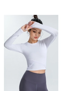 Détail du haut de yoga blanc court avec taille croisée et passe-pouces pour le sport