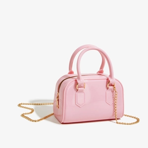 Détail du sac à main rose en PVC brillant avec bandoulière en chaîne dorée chic