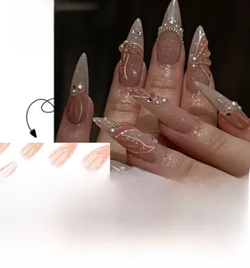 Détail de faux ongles en amande rose nude avec des vagues blanches et des perles