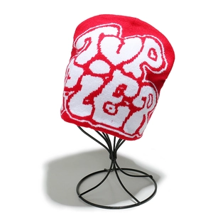 Détail du bonnet en tricot rouge et blanc montrant des motifs de lettres jacquard