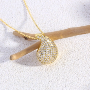 Luxury 18k gold teardrop pendant necklace with white zircon pavé on a wooden branch