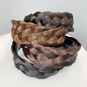 Detailed view of three stacked braided hairbands in brown and black synthetic hair textures