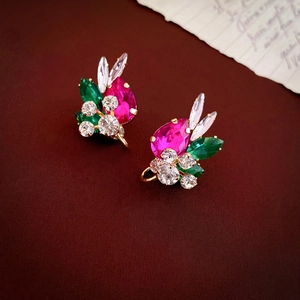 Detailed shot of teardrop rose red and green gems with sparkling rhinestones on gold studs