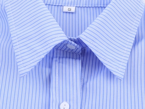 Dettaglio colletto camicia a righe blu con trama definita ed etichetta taglia S bianca