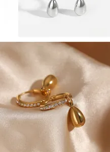 Detailed close-up of gold-plated teardrop pendant earrings with micro-pave white zircon