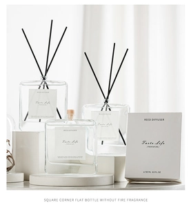 Three minimalist glass aroma diffusers with black reeds in a stylish white gift box