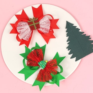 Detailed view of red and green Christmas bow hair clips with festive gift and tree charms