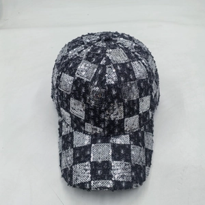Detail of sequined checkerboard pattern and frayed denim edge on a baseball cap