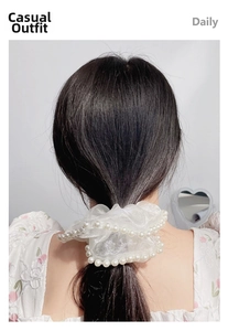Detail of elegant mesh organza scrunchie with faux pearl edges on a model's hair