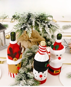 Close-up of knitted Christmas wine bottle covers featuring Santa, reindeer and snowman