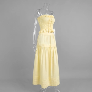 Detail of light yellow smocked crop top and layered skirt with delicate lace trim