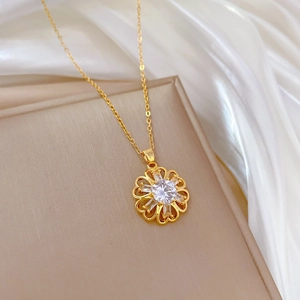 Elegant gold hollow flower necklace with sparkling zircon pendant on silk background