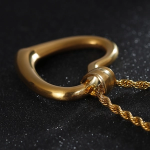 Detailed view of a gold heart pendant with polished finish and twist chain necklace