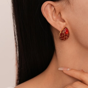 Vue détaillée de boucles d'oreilles vintage en maille dorée et cristal rouge