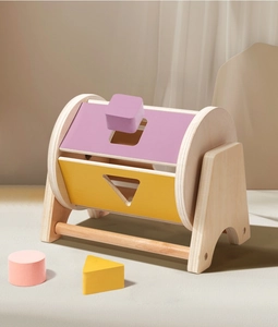 Close-up of wooden Montessori shape sorter with colorful blocks and spinning drum for toddlers