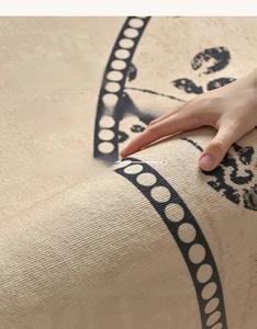 Close-up of beige round woven rug with black geometric patterns showing thick texture