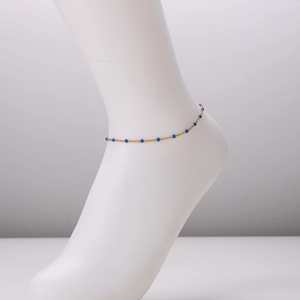 Minimalist 18k gold plated stainless steel anklet with blue enamel beads on a model