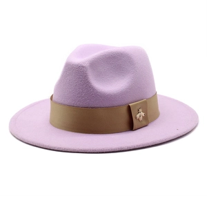 Detail of lavender wool fedora hat featuring light brown ribbon and golden bee brooch