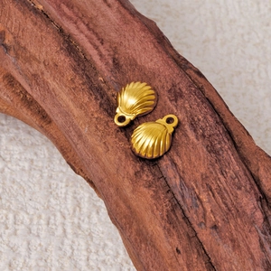 Golden 304 stainless steel seashell pendants on natural rustic wooden background