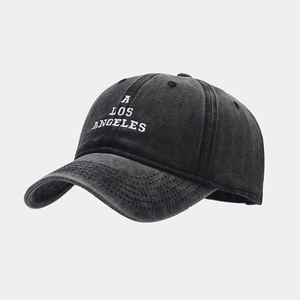 Close-up of A LOS ANGELES embroidery on a washed black cotton baseball cap surface