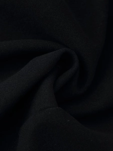 Detailed macro view showing the textured black wool blend fabric of the slim-fit long coat