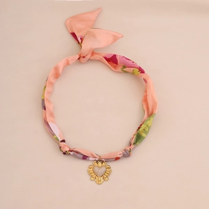 Detailed view of pink floral silk scarf necklace with a golden heart pendant
