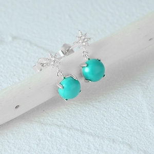 Macro detail of S925 silver turquoise earrings featuring an octagonal star and green beads