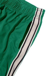 Close-up of bright green joggers featuring white side stripes and elastic waistband texture