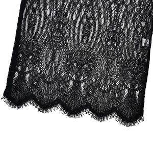 Macro shot of black floral lace fabric featuring delicate scalloped eyelash trim edges