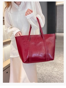 Close-up of red oil wax leather tote bag with glossy finish and double shoulder straps