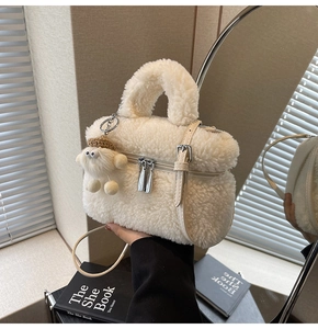 Detail of cream sherpa fleece handbag featuring plush handle and detachable strap