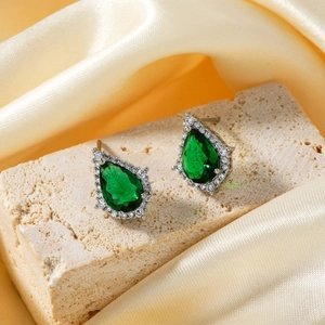 Detail view of silver water drop earrings with green gemstone and micro-pave crystals