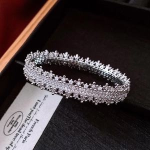 Detailed close-up of a silver lace-edge pave set bangle on black velvet display