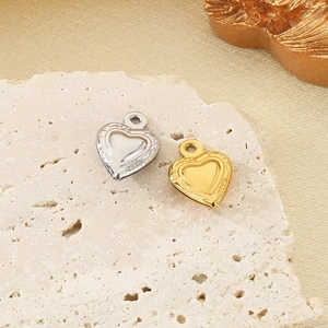 Dettaglio macro di pendenti a cuore in rilievo in oro 18 carati e argento su pietra