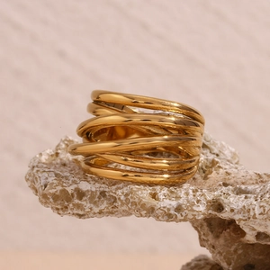 Detail of 18K gold-plated stainless steel ring with woven twisted design on rock