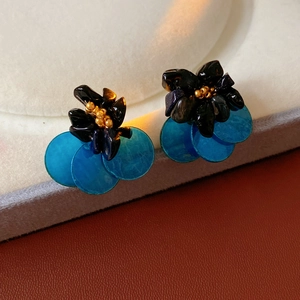 Detail of vintage flower stud earrings featuring black beads and blue shell petals
