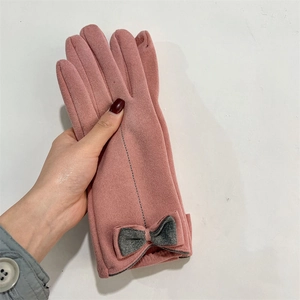 Detailed view of pink winter gloves with grey bow decoration and fleece lining