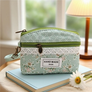 Green floral fabric coin purse with double zippers, lace trim and handmade bag label