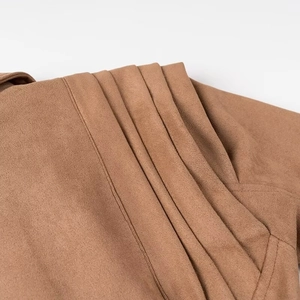 Macro detail of the pleated shoulder stitching on the brown faux suede biker jacket